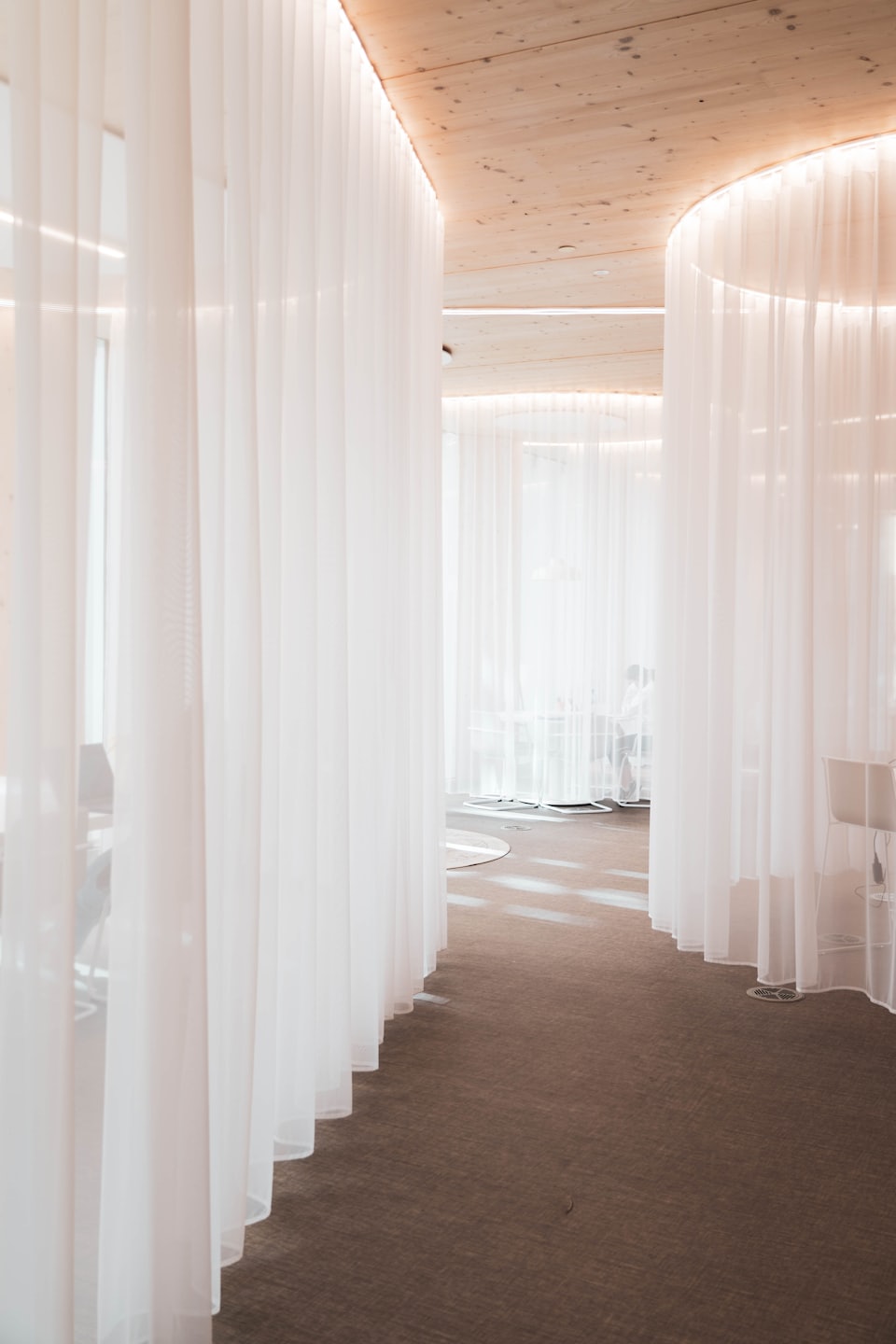 Sunlight filters through sheer white curtains in a modern office space.